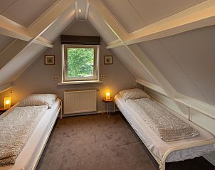 Knusse zolderkamer in vakantiehuis 3685, Oosterend Texel, met twee eenpersoonsbedden en dakraam.