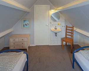Ruime zolderkamer in bungalow 3685, Oosterend Texel, met wastafel en comfortabele slaapplaatsen.