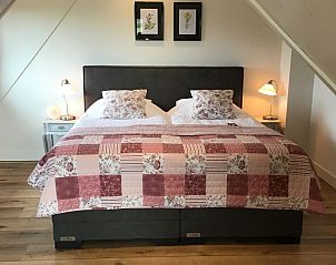 Gezellige slaapkamer in De Borage Texel, Oosterend, met een groot tweepersoonsbed en warme verlichting voor een rustgevende nachtrust.