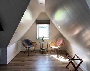 Zithoek met uitzicht in De Borage Texel, Oosterend, biedt comfortabele stoelen en een tafel voor ontspanning en genieten van de omgeving.