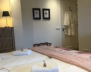 Slaapkamer in De Borage Texel, Oosterend, met warme verlichting en zachte handdoeken voor een gastvrij en huiselijk gevoel.