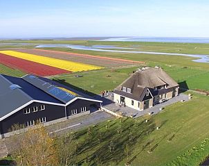 Luchtfoto van De Borage Texel bed and breakfast in Oosterend, omgeven door kleurrijke tulpenvelden en weidse landschappen.
