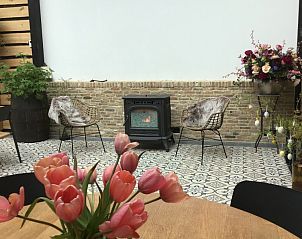 Gezellige binnenruimte van De Borage Texel, Oosterend, met houtkachel en sfeervolle decoraties voor een warme ambiance.