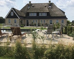 Zonnig terras bij De Borage Texel, Oosterend, met comfortabele ligstoelen en uitzicht op de tuin en natuurvijver.