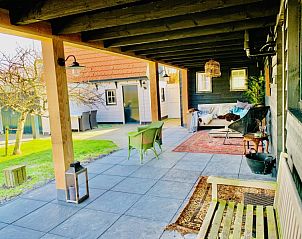 Gemtliche Veranda im Ferienhaus 't Kaaps Huussie in Oosterend, Texel mit bequemen Sitzgelegenheiten.