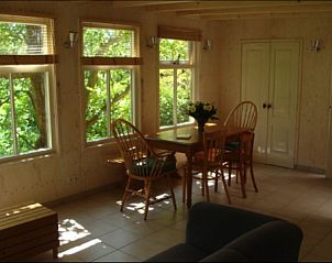 Gezellige zithoek in De Fazant, bungalow in Oosterend, Texel, met uitzicht op groene tuinen en veel natuurlijk licht.