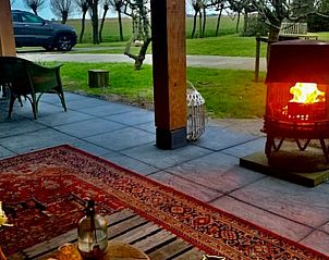 Gemtliche Terrasse mit Kamin im Ferienhaus in Oosterend, Texel, ideal fr Abende in der Natur.