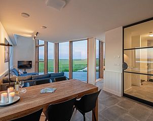 Essecke im Ferienhaus in Oosterend, Texel mit Glaswand und Blick auf die Texeler Natur.