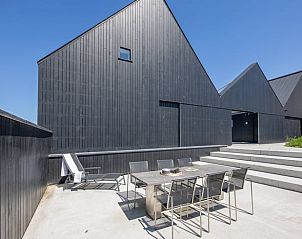 Auenbereich des Ferienhauses in Oosterend, Texel mit modernen Sitzgelegenheiten und Sonnenlicht.