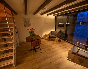 Gemtliches Wohnzimmer am Abend im Ferienhaus in Oosterend, Texel mit Holzdetails.