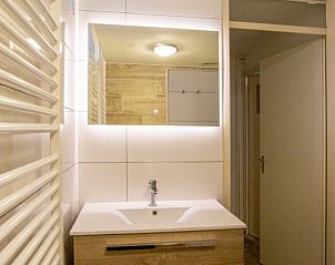 Verlichte badkamer met wastafel in vakantiehuis Nieuwlanderweg 69, De Koog, Texel, Waddeneilanden.