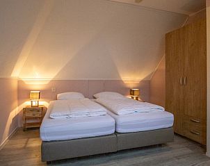 Sfeervolle slaapkamer met tweepersoonsbed in vakantiehuis Nieuwlanderweg 69, De Koog, Texel, Waddeneilanden.