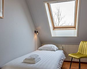 Einzelzimmer im Ferienhaus in Oosterend, Texel, Ferienhaus mit Dachfenster und Stuhl auf den Watteninseln.