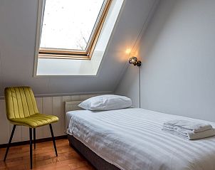 Helles Schlafzimmer im Ferienhaus in Oosterend, Texel, Ferienhaus mit Einzelbett und Dachfenster auf den Watteninseln.