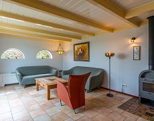 Gemtliches Wohnzimmer im Ferienhaus in Oosterend, Texel, mit bequemen Sofas und Holzofen.