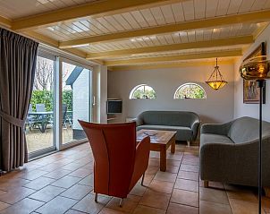 Helles Wohnzimmer im Ferienhaus in Oosterend, Texel, mit Schiebetr zur Terrasse und Gartenblick.