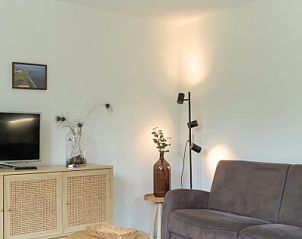 Gemtliches Wohnzimmer im Ferienhaus Typ I - Nr. 59 Mallemok, Oosterend, Texel, mit bequemem Sofa und moderner Einrichtung.