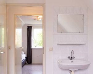 Schlafzimmer mit Waschbecken in Typ I - Nr. 59 Ferienhaus Mallemok, Oosterend, Texel, bietet Komfort und Privatsphre.