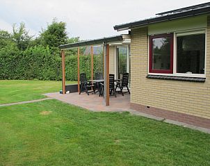 Veranda des Ferienhauses de Toes 1 in Oosterend Texel mit Sitzgelegenheit und grnem Garten.