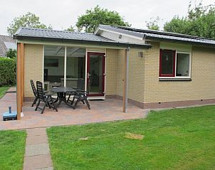 Terrasse des Ferienhauses de Toes 1 Oosterend Texel mit Gartenmbeln und grner Umgebung.