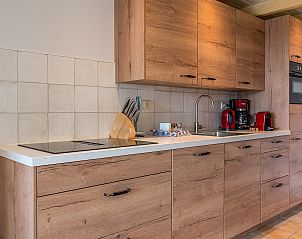 Stijlvolle keuken in vakantiehuis Daalder, Oosterend, Texel, met houten kasten en moderne apparatuur.