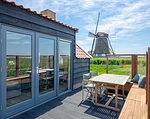 Terrace by ZoWad - Mhlenhaus Beaufort, Ferienhaus in Oosterend Texel, mit Holzmbeln und Blick auf die Mhle.