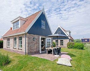 Gemtliche Auenterrasse des Ferienhauses De Kokkel in Oosterend Texel mit Sonnenschirm und Sitzkissen.