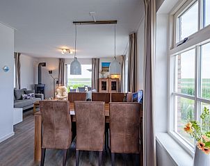 Essecke im Ferienhaus De Kokkel in Oosterend Texel mit groem Tisch und Blick auf die Natur.