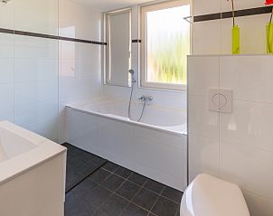Moderne badkamer met bad en douche in Type II+ - nr. 91 Dwergstern vakantiehuis in Oosterend, Texel.