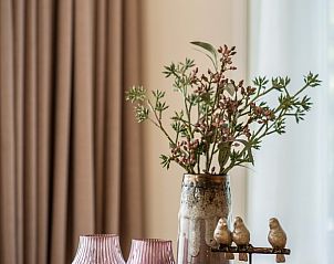 Gezellige binnenruimte in Vakantiepark So What, De Koog, Texel. Stijlvolle bungalowdecoratie met vaas en lamp, ideaal voor ontspanning.