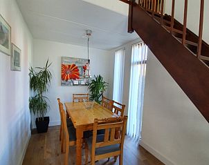 Eetruimte met houten tafel in Alkema bungalowverhuur Gortersmient, Texel met kunst aan de muur.