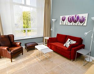 Stijlvolle zithoek in Bed & Bed, Texel, met kleurrijke kunst en comfortabele meubels voor een gezellige sfeer.