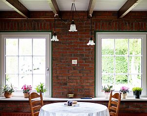 Eetkamer met uitzicht op de tuin in Het Rge Landje, vakantiehuis in Dennenbos, Texel.