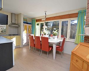 Dining room in Holiday Home De Nagtegaal 15, Texel with large dining table and lots of natural light.