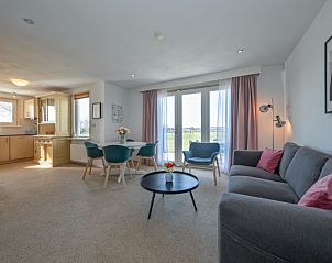 Helles Wohnzimmer von Haus 7 in De Dennen, Texel, mit bequemen Sitzgelegenheiten und Blick auf die Natur.