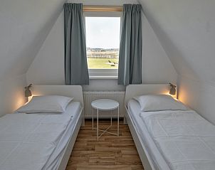 Zweites Schlafzimmer in Cottage 7, De Dennen, Texel mit zwei Einzelbetten und Blick auf die Natur.
