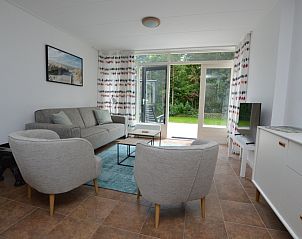 Gemtliches Wohnzimmer des Ferienhauses de Parel 182 in De Dennen, Texel mit Blick auf den Garten.