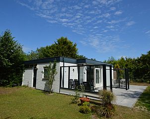 Auenansicht des Ferienhauses de Parel 182 in De Dennen, Texel mit Terrasse und grnem Garten.