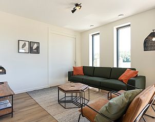 Comfortable living room of Holiday Home 2 in De Dennen, Texel with green sofa and decorative elements.