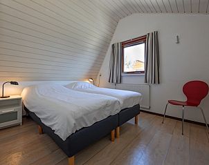 Comfortabele slaapkamer met tweepersoonsbed in Vakantiehuis Gortersmient 214, De Dennen, Texel. Rustig slapen op de Waddeneilanden.