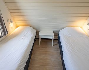 Gezellige slaapkamer met twee eenpersoonsbedden in Vakantiehuis Gortersmient 214, De Dennen, Texel. Ideaal voor een familievakantie op de Waddeneilanden.