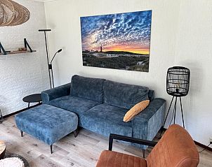 Cozy living room in vacation home de Parel 162, Bungalowpark de Parel, De Dennen, Texel, with comfortable sofa and cozy decoration.