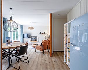 View of living room and kitchen in vacation home de Parel 162, Bungalowpark de Parel, De Dennen, Texel, with retro fridge and modern design.