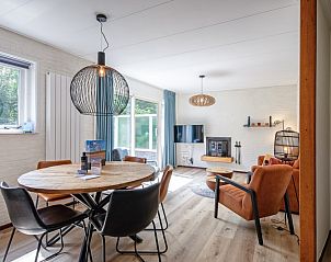 Bright dining and living room in vacation home de Parel 162, Bungalowpark de Parel, De Dennen, Texel, with large windows and comfortable interior.