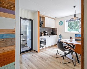 Kitchen and dining area in vacation home de Parel 162, Bungalowpark de Parel, De Dennen, Texel, with a colorful wooden cabinet.