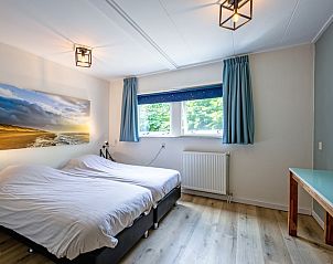 Bedroom with double beds in vacation home de Parel 162, Bungalowpark de Parel, De Dennen, Texel, overlooking nature.