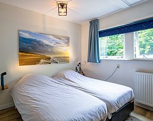 Comfortable bedroom in vacation home de Parel 162, Bungalowpark de Parel, De Dennen, Texel, with art on the wall and lots of light.