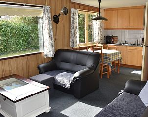 Ruime woonkamer in De Strandloper vakantiehuis, De Koog, Texel met uitzicht op tuin.