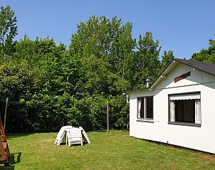 De Strandloper bungalow in De Koog, Texel met groene tuin en zitbank.