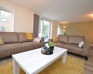 Gemtliches Wohnzimmer des Ferienhauses De Nagtegaal 23, De Dennen, Texel, mit viel Tageslicht.